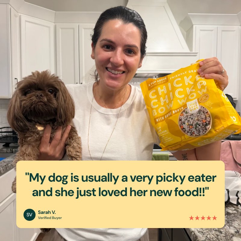A happy customer holding her dog and a bag of Chicka Chicka Bow Wow